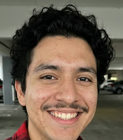 Photo B: a man with curly black hair and a mustache in red flannel (AI-generated person)